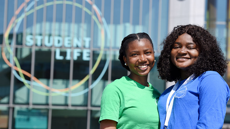 Two students in front of the Student Life building